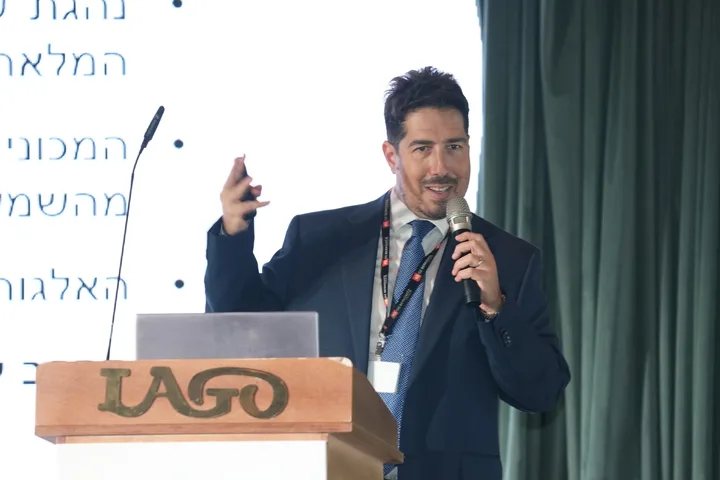 A speaker presenting with a microphone and presentation remote