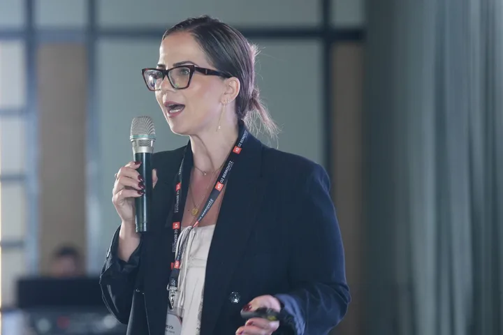A presenter speaking into a microphone during the conference