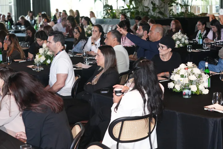 Conference guests seated at tables during a session